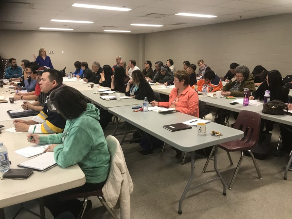 A full board room of eager participants at a workshop/program.