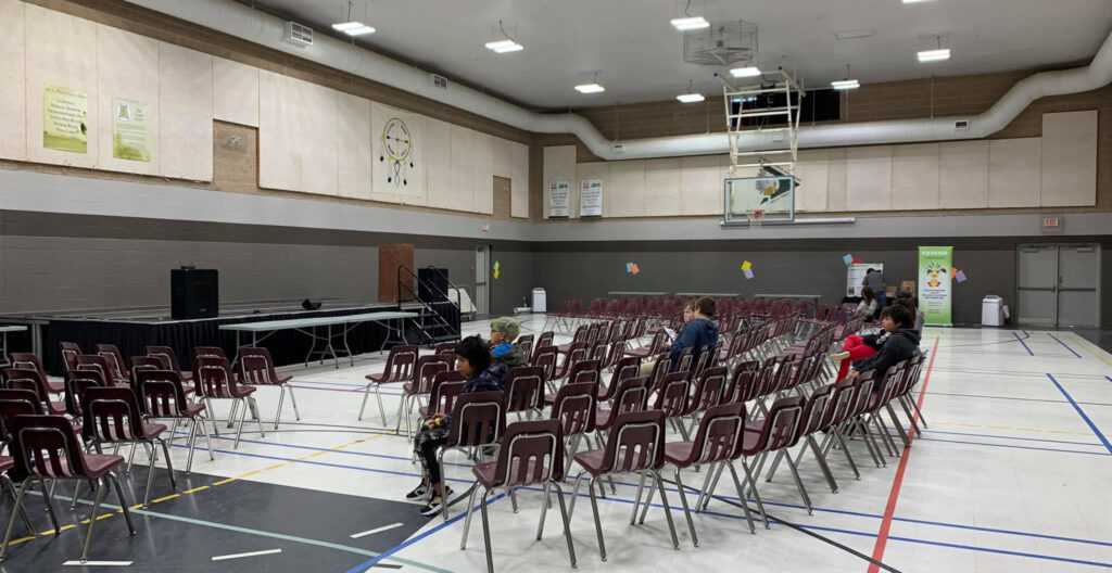 A stage is set up, chairs surround it as a few people wait for the entertainment to begin.